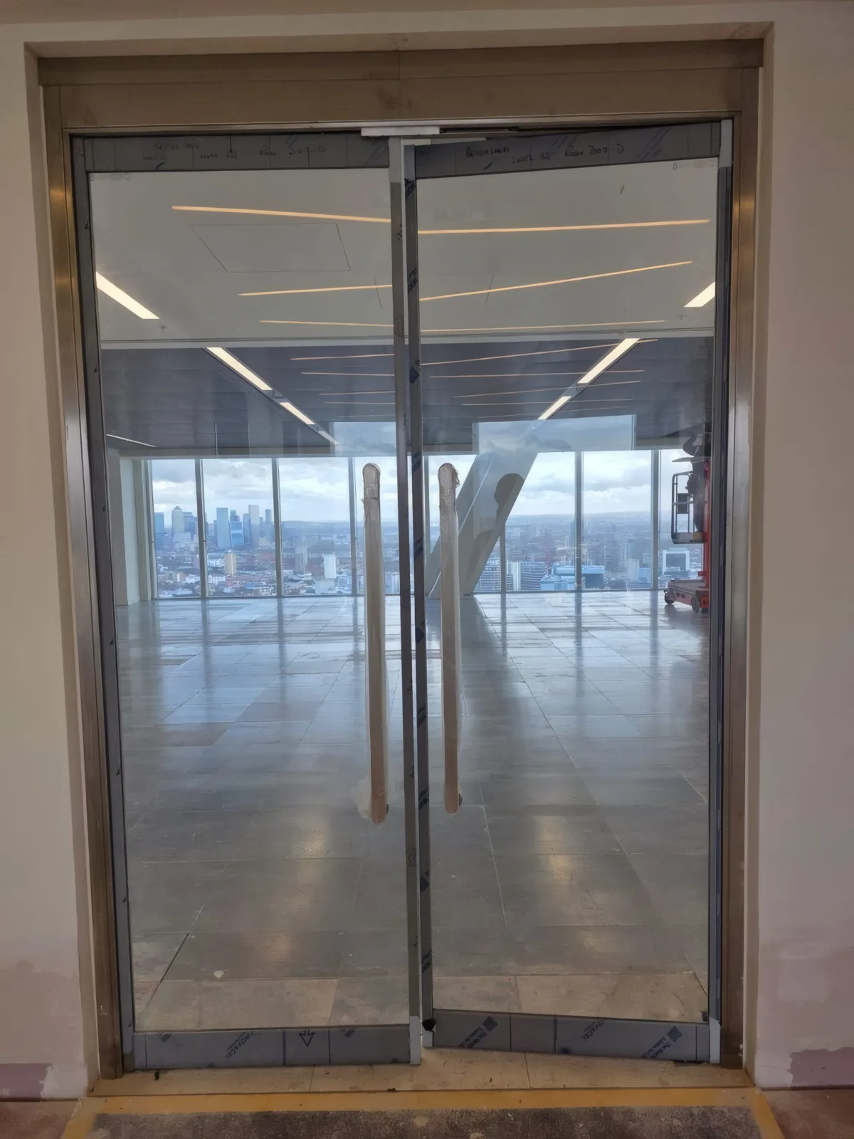 Fire-rated glazed double doors installed by OMFC for British Land, with London views beyond.