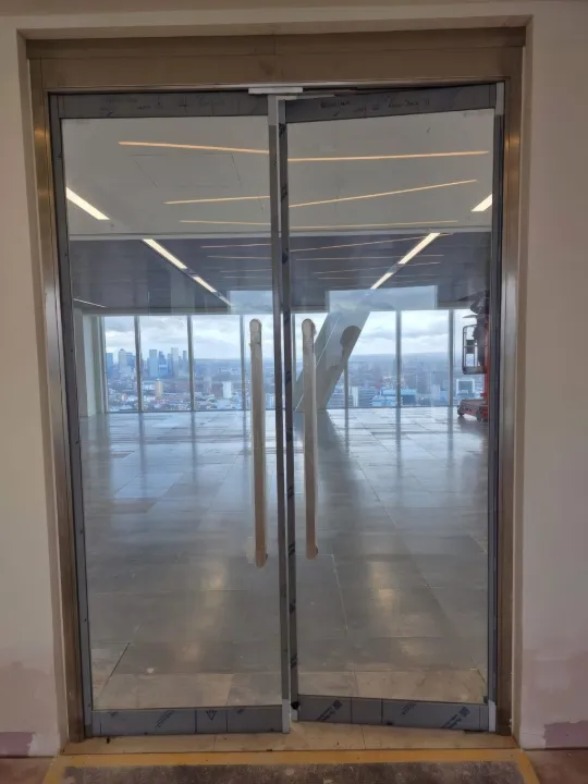 Fire-rated glazed double doors with London views beyond.
