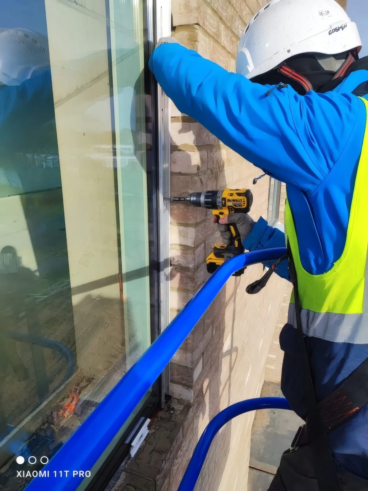Fixing a glazing unit frame into the brickwork from an access platform.