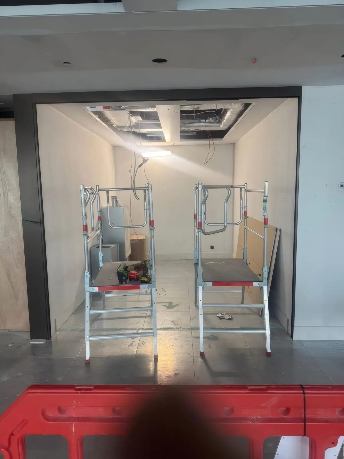 Access equipment positioned within a partition opening ahead of glazing and door installation.