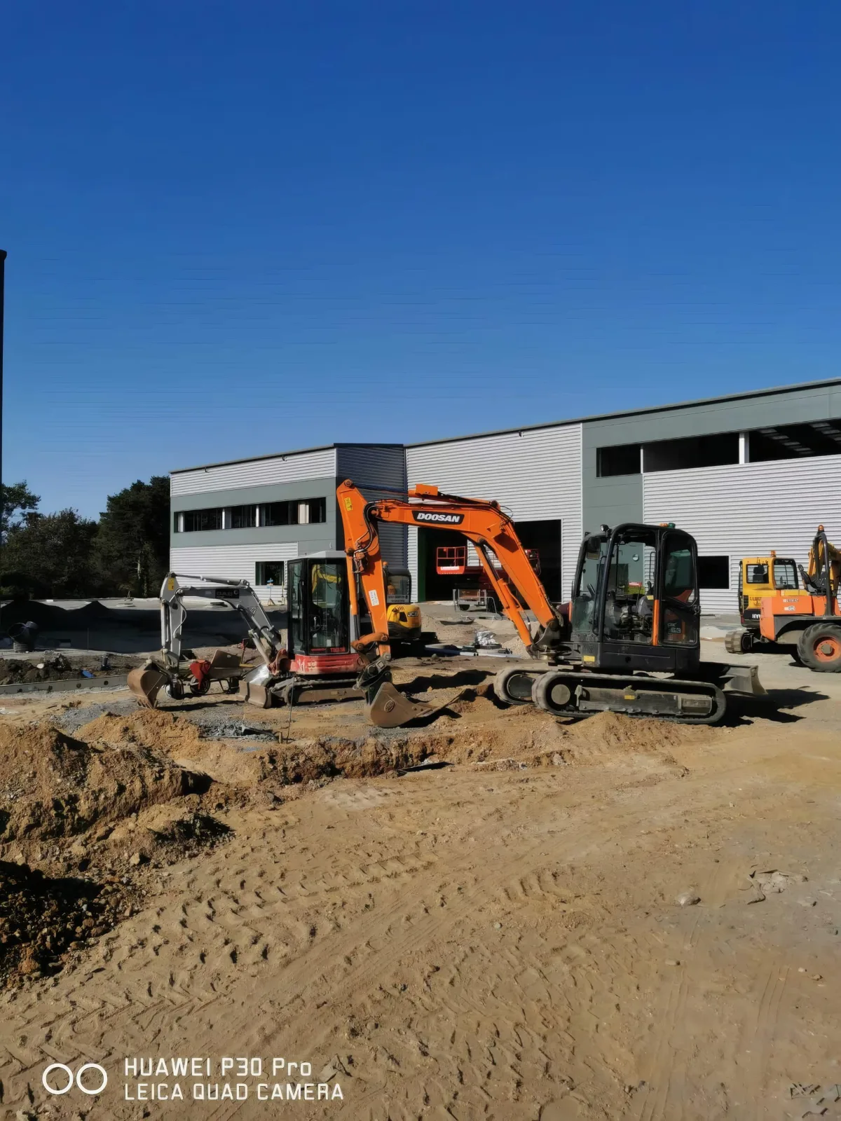 Excavators at work in front of the units.