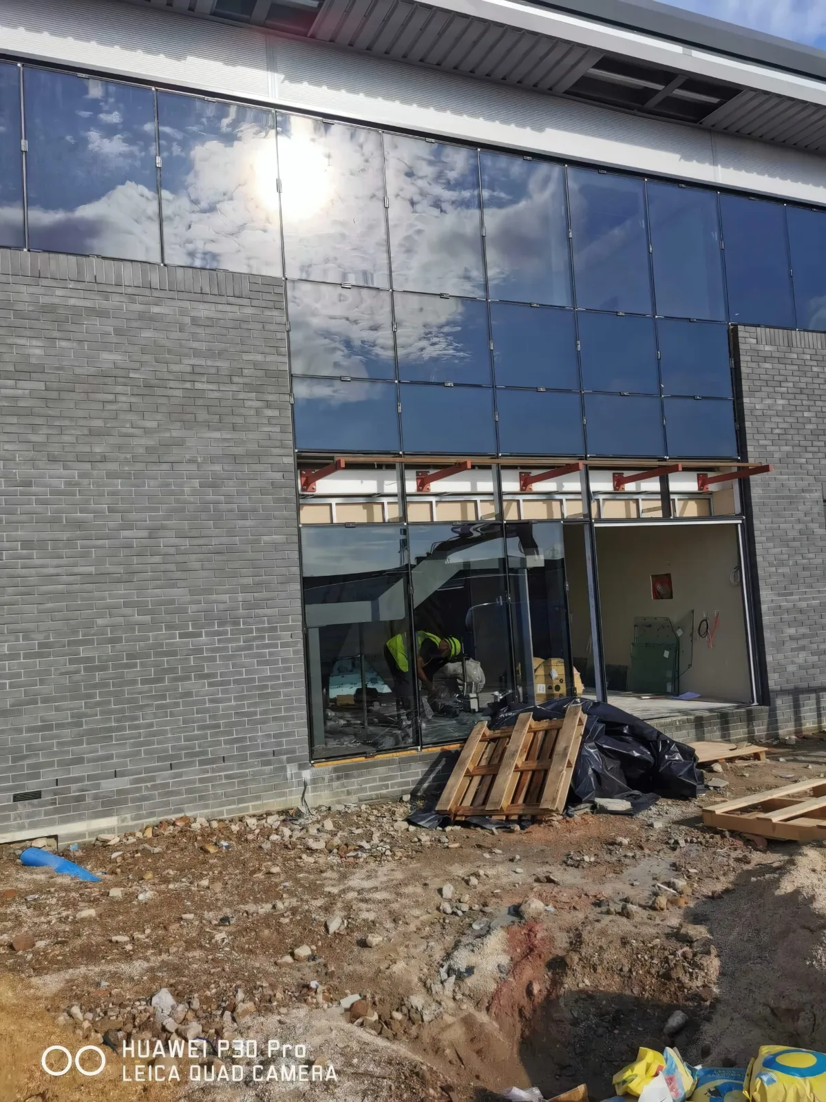 An installer at work inside the glazed entrance screen.