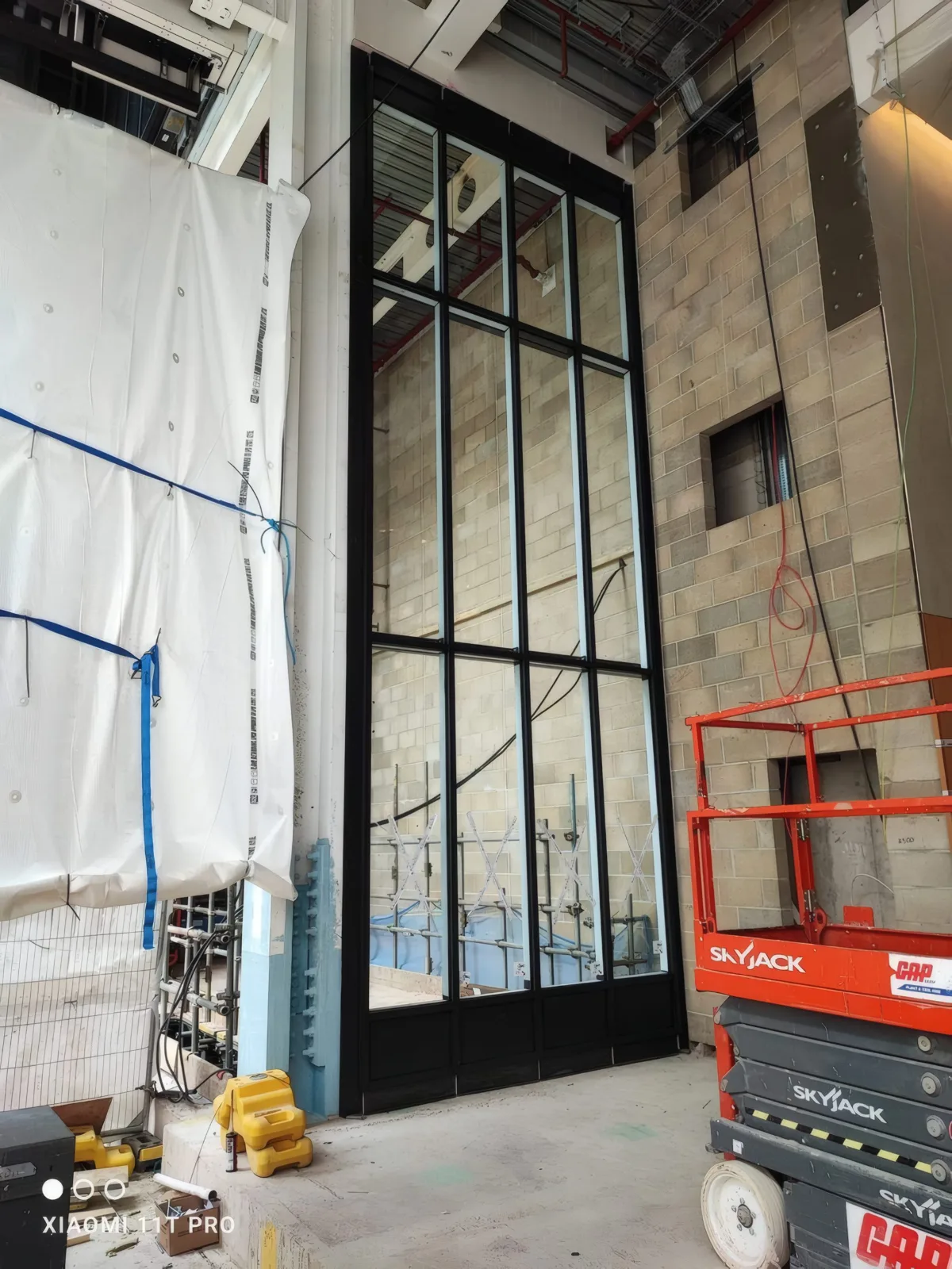 A full-height black-framed glazed screen, glazed and sealed.