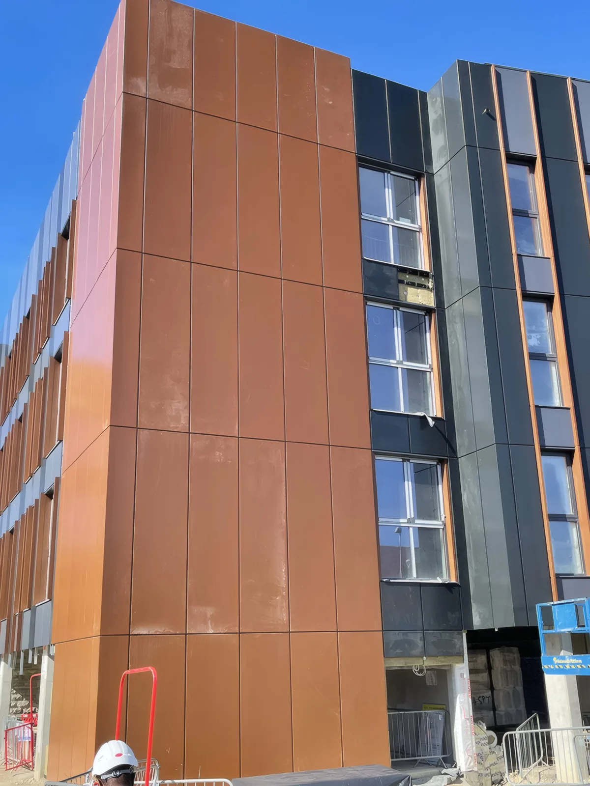 Copper-coloured cladding panels at a corner, seen from below.