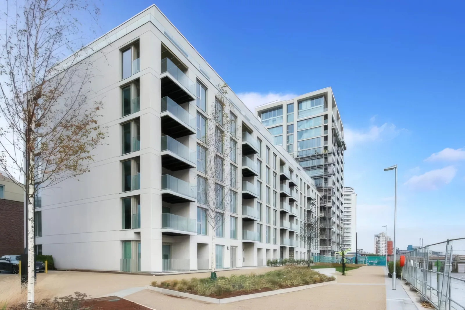 White apartment buildings along the riverside walk.